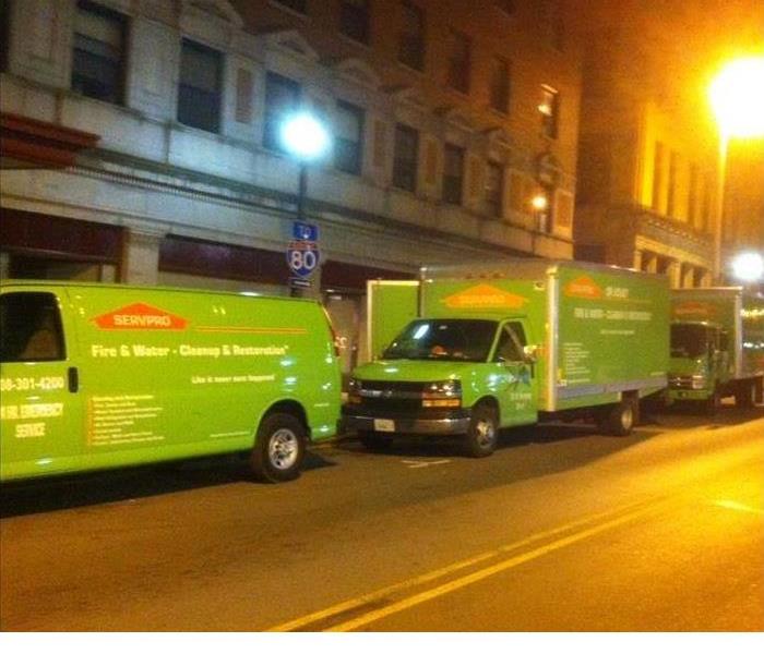 Green SERVPRO trucks in front of commercial building